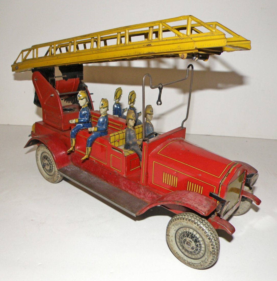 LARGE DISTLER FIRE LADDER TRUCK: Complete with ladder and all firemen, Shows some aging and scratching. Left rear wheel has litho loss. 17 1/2" l