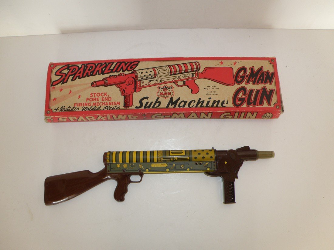 BOXED MARX SUBMACHINE GUN: Military sub-machine gun in a G-Man box. Box is missing two inner flaps and shows wear and creasing. Box is Good-VG. Toy is not working with only slight wear. 21 1/2" long