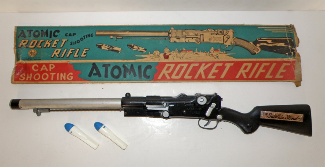 BOXED MARX ATOMIC ROCKET RIFLE: Working cap gun with two rockets shows some play and use wear. Original box has missing end panels and damage. Box rating: Fair 28" long