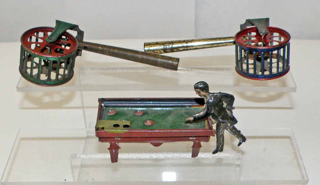 LOT OF THREE PENNY TOYS: Includes pool player and two squirrel cage whistles. Largest 4 3/4" long