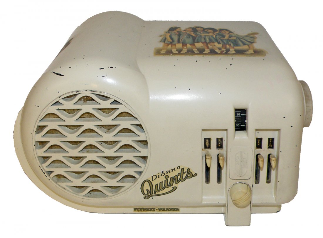 DIONNE QUINTUPLETS STUART WARNER RADIO: Largest of three sizes made with some scattered chipping to painted surface and minor wear to decals. Works but needs antenna. Missing back cover. 12 1/2" long x 7 1/2" tall