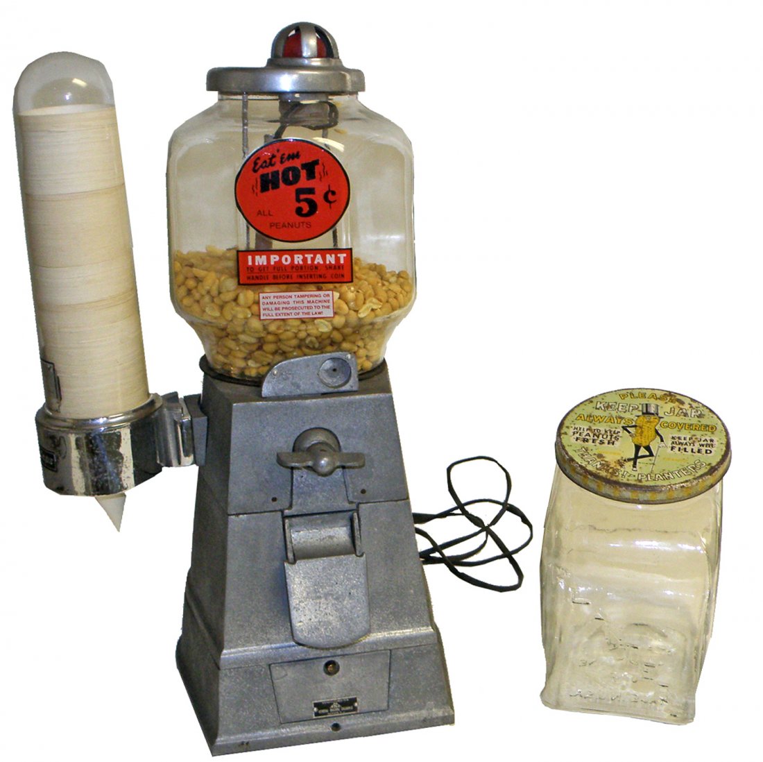 ASCO HOT NUT VENDOR: 1946 Hot nut vendor with cup dispenser. Replaced decal. Comes with a planters peanut jar. Wear to lid. 21 1/2" tall x 11" wide