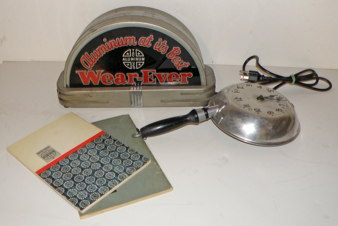 WEAR-EVER COOKWARE SIGN AND CLOCK: Scarece light up sign with Art Deco design. Works fine. No flaking to reverse on glass. Also comes with a Wear-Ever frying pan clock which was a scarce company premium. Clock mechanism replaced. large