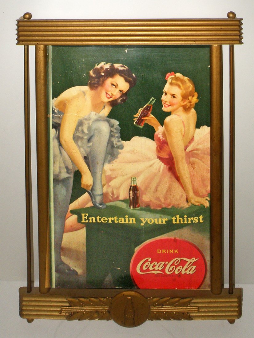 COCA-COLA CARDBOARD SIGN IN ORIGINAL FRAME: 1942 sign depicts ballet dancers. Cardboard has some surface wear and creasing. Original Kay frame has light surface wear and soiling. Cardboard sign is Good 32 1/2" tall x 21 1/4" wide