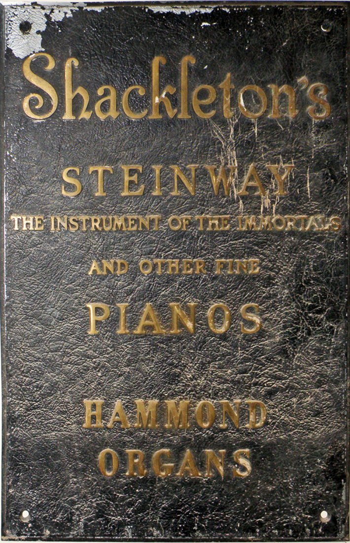 CAST IRON SHACKLETON'S PIANO SIGN: Outdoor store sign promotes Steinway Pianos and Hammond Organs. Some surface wear. 23" x 15 1/2"