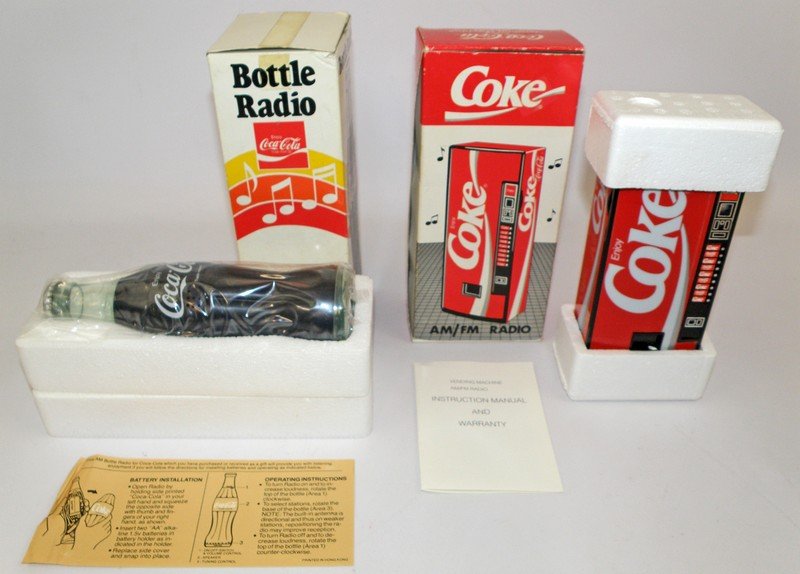 TWO BOXED COCA-COLA RADIOS: Hong Kong vending machine radio and bottle radio. Bottle radio appears unused. Both boxes have original inserts and paperwork. Boxes- Fine-VFlargest 9" tall