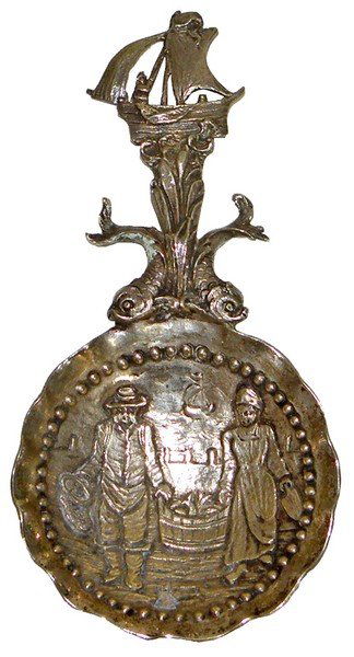 SILVER MONKEY SPOON: Marriage spoon. Handle depicts sailing ship and Dolphins. Bowl depicts a couple with bucket of fish. Unknown hallmark in bowl, probably sterling. Weighs 1. 2 oz. 4. 5" long