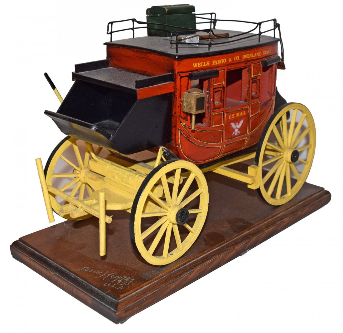 WELLS FARGO OVERLAND STAGE BY OSCAR CORTES: This and the following lot were made by well known, Folk artist, Oscar Cortes and his family. All pieces are hand made from wood, metal, vinyl and sometimes, leather. Dated 1995. 9'' tall