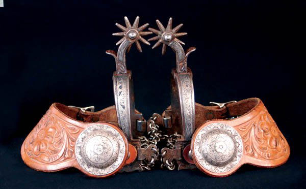 August Buermann California Spurs: Early "Star" and Hand Forged Steel marks. Fine condition with traces of blue remaining. Silver inlaid with deep cast chasing on bands, double chains and 10-pt 1 3/4" rowels. Deep floral tooled leather