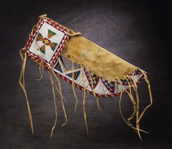 Gros Ventre Beaded Knife Sheath: Collected at Fort Belknap, Montana. Geometric designs on native tanned hide, with edges wrapped in red trade cloth and hide. Has classic triangular cut-out. Fine condition, c. 1900. Attached: Richard 