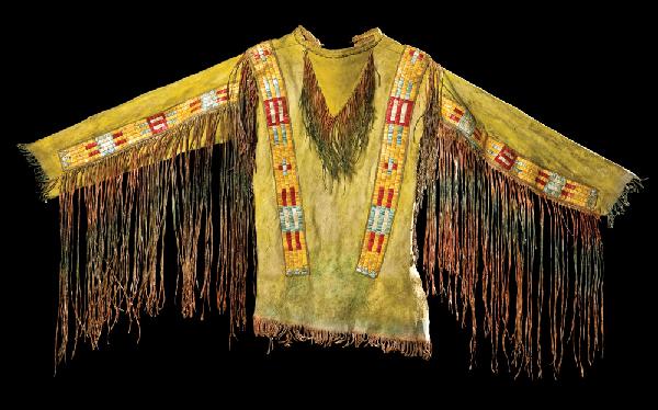 Quilled Northern Plains Mens Warrior Shirt: Geometric designs, quilled strips over shoulders and down arms in red, blue, yellow and white, on native tanned hide. Red and green fringe along sides, down sleeves and at the bib. Body of shirt is dy