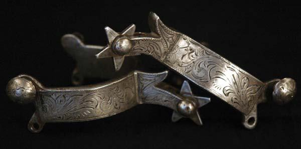 Full Silver Overlaid Wyoming Spurs: Cheyenne split heelband spurs in the style of Schnitger and other area makers. Well executed engraving with short shanks and star rowels. These could very well be from the Edward Bohlin shop