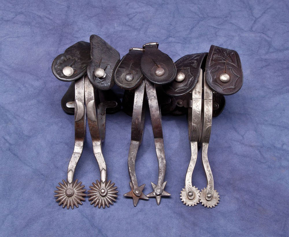 3 Pair of August Buermann "Daisy" Spurs: All with early "Hand Forged Steel" markings a) Minty blanks with later sterling overlay on both sides. High quality engraving. Swinging buttons with sterling caps added. Fine condition tooled Heiser s