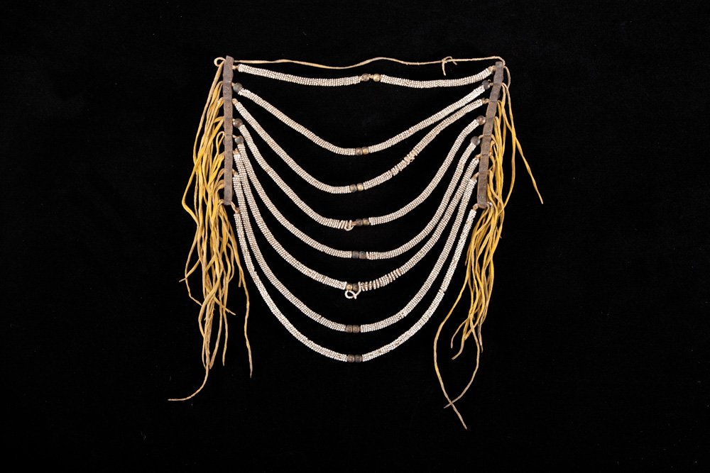 Two Framed & Beaded Artifacts: a) 14” x 9” early Northern Plains loop necklace, native and commercial hide with seed and brass beads. Good condition, circa 1870; b) A loom beaded dance piece with bead and shell suspensions. Goo