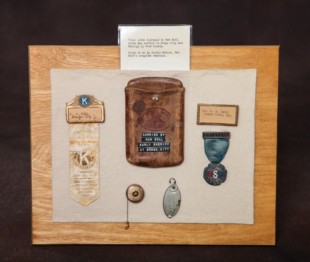Ham Bell, Dodge City Sheriff Collection: Historical items carried by H.B. Bell as Sheriff of Dodge City, Kansas: a) Leather wallet with Masonic pin; b) 1929 Kiwanis badge; c) Suspension delegate ribbon and fob from 1909 National Sheriff's As