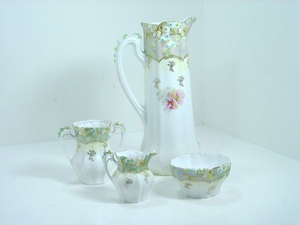 R S GERMANY ANTIQUE PORCELAIN CHOCOLATE POTN: R S GERMANY ANTIQUE PORCELAIN CHOCOLATE POT WITH MATCHINGCREAMER, SUGAR, AND SPOONERDECORATED WITH FLOWERS AND GOLD ACCENTS, plus shipping