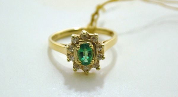 14KT Y.G. .75CT EMERALD AND DIAMOND RING: SET WITH APPROX. .50CT OVAL CUT LIGHT EMERALD AND .25CT G-H COLOT SI QUALITY DIANMONDS TWT 3.7 GRAMS SIZE 6.50 BUYER ARRANGES SHIPPING