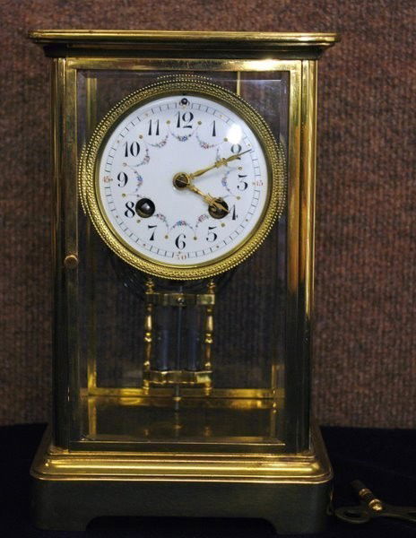 TIFFANY CRYSTAL REGULATOR CLOCK CIRCA 1900S: BRASS CRYSTAL 8 DAY REGULATOR, CHIMES ON THE HOUR AND HALF HOUR, MERCURY PENDULUM, MOVEMENT SIGNED TIFFANY & CO 10 1/2" TALL, FANCY DESIGN ON DIAL. HAS SOME WEAR ON CASE.