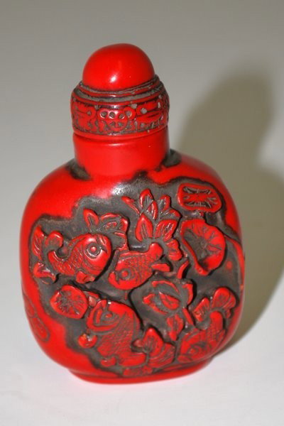 ORIENTAL CINNABAR SNUFF BOTTLE: ORIENTAL CINNABAR SNUFF BOTTLE DARK REDDISH COLOR WITH RELIEF CARVING OF FISH, MINUS SPOON, 3" TALL