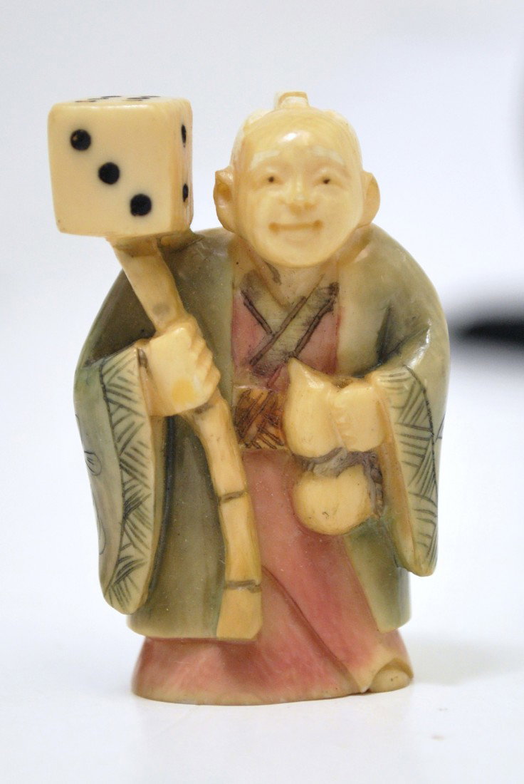 ANTIQUE POLYCHROME IVORY NETSUKE: POLYCHROME IVORY NETSUKE OF A ORIENTAL MAN HOLDING ONE DICE ON A STICK, 2 " TALL