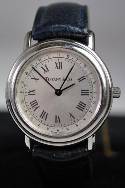 UNISEX S/S TIFFANY WATCH: QUARTZ GREY DIAL COMES ON ORIGINAL BLACK STRAP WITH TIFFANY BUCKLE HAS POUCH CASE 36MM WITH CROWN