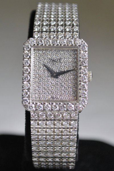 18KT W.G. PIAGET CUSTOM 12.00CT DIAMOND WATCH: SET WITH APPROX. 12.00CT AFTERMARKET G-H COLOR VS TO SI QUALITY DIAMONDS THROUGHOUT BAND AND BEZEL PLUS DIAMOND DIAL POSSIBLY FACTORY MANUAL WIND TWT 69.0 GRAMS BAND 6.50" LONG CASE 22MM WIDE