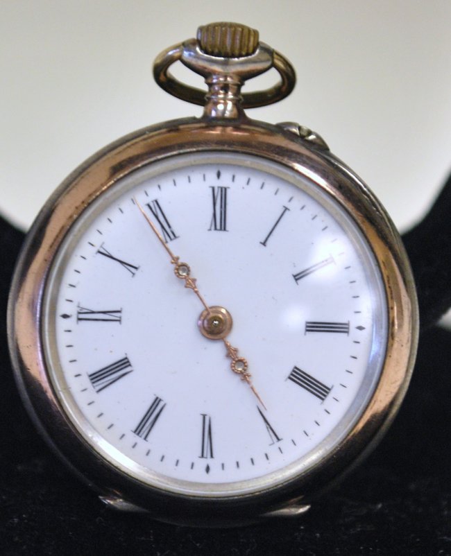 LADIES STERLING ARNEX POCKET WATCH: O SIZE CASE MARKED 800 EUROPEAN MOVEMENTSIGNED ARNEX HAS LION ON MOVEMENT WHITE DIAL PINK GOLD PLATED ACCENTS ON CASE CASE BACK HAS HAND PAINTED ACCENT SCENE