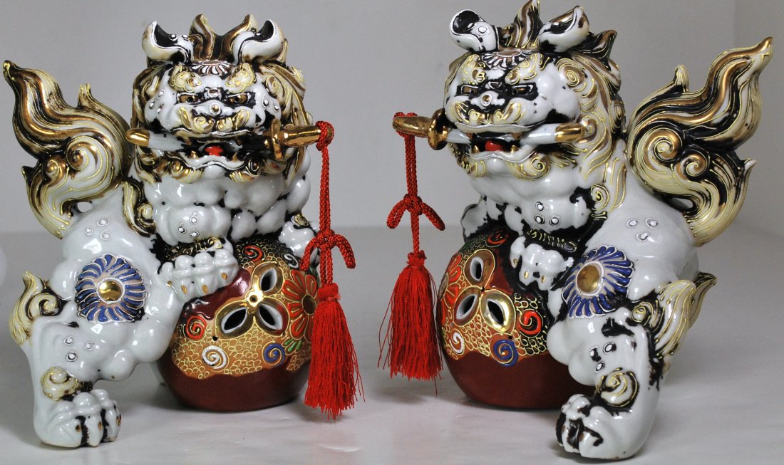 PAIR OF PORCLAIN FOO DOGS: SIGNED ON BOTTOM OF BALL. 7" LONG X 8" TALL