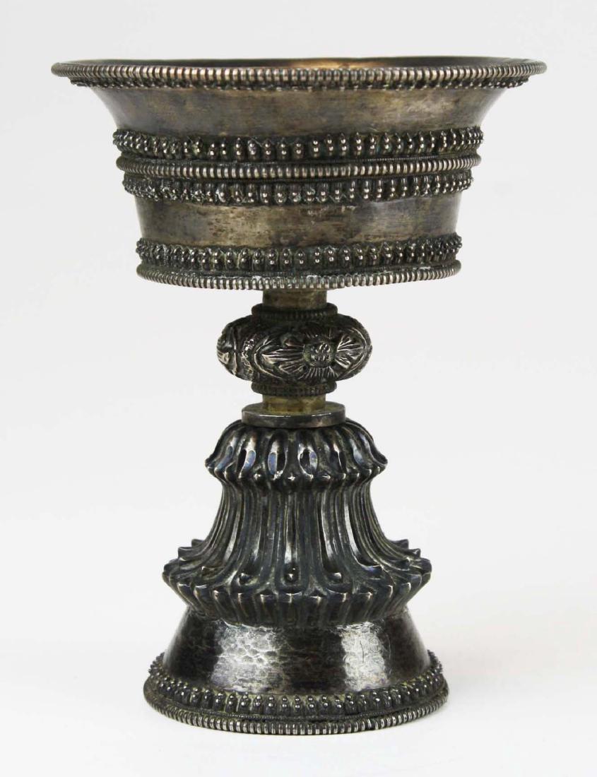 fine 18th or 19th c. Tibetan or Nepalese silver butter: in chalice form applied bell form base with hand hammered repousse floral and lotus petal decoration 5.25" x 4"