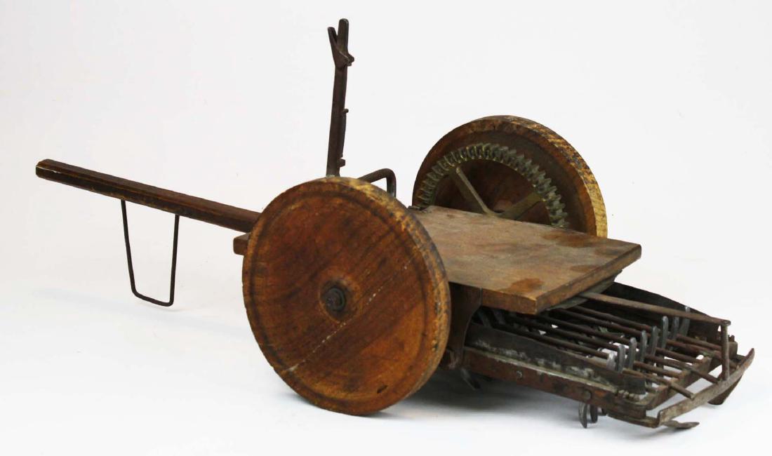 Salesman sample 19th c hay cultivator: Salesman sample or patent model of hay cultivator. Working model made of iron and wood. Iron shovel under horse drawn carriage draws hay into gear mechanical iron teeth which circulate material and pl