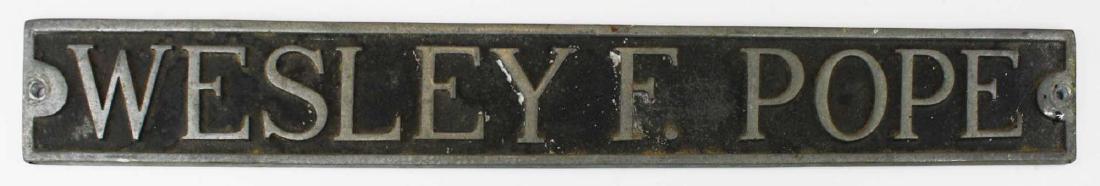 mid 20th c Wesley F Pope door sign: mid 20th c Wesley F Pope cast aluminum door sign (Wesley Pope was a cabinetmaker in Jeffersonville, VT), length 23 1/2"