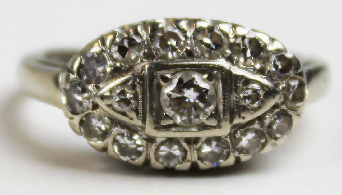 Diamond Edwardian 14k white gold ring: Fine diamond Edwardian 14 k white gold cocktail ring having .15 ct round cut center diamond in oval setting surrounded by 16 .04 ct round cut diamonds. Total carat weight .79. Ring size 7.