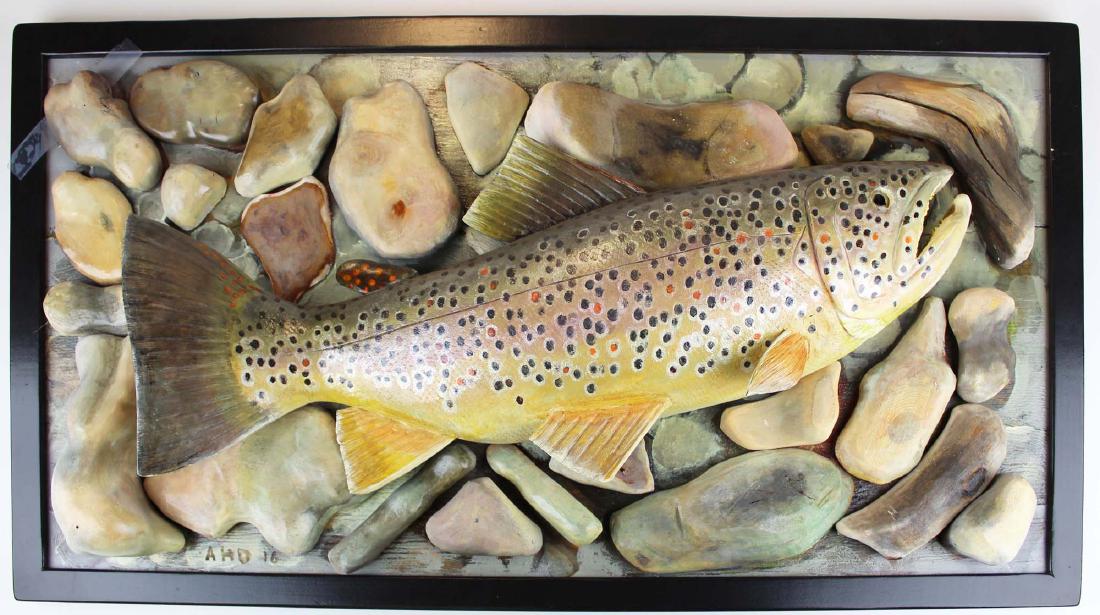 A Diem carving of trophy landed brown trout: Signed Albert Diem carving of 24" long landed brown trout. Mounted to a board with carved and painted river stones. Finely carved and painted. Good overall condition. 33" x 18"