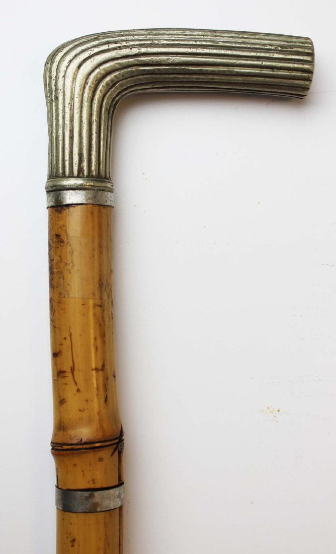 Sword cane: Ca. 1900 sword cane with a ribbed nickel silver grip and bamboo case. 20" square steel blade.