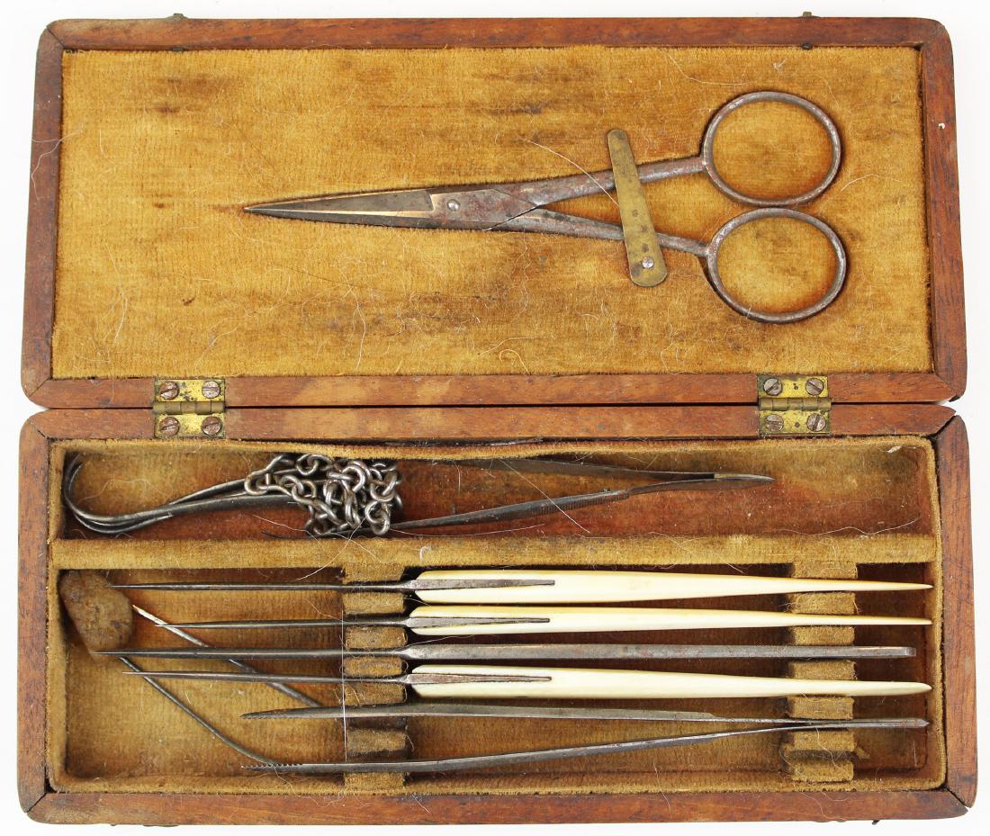 19th c field surgical kit: Mid 19th c field surgical kit. Walnut box with fitted velvet lined interior having scissors, 4 various flem's or razor knives, chain hook set, needles, and two small forceps. 7" x 3" x 1".