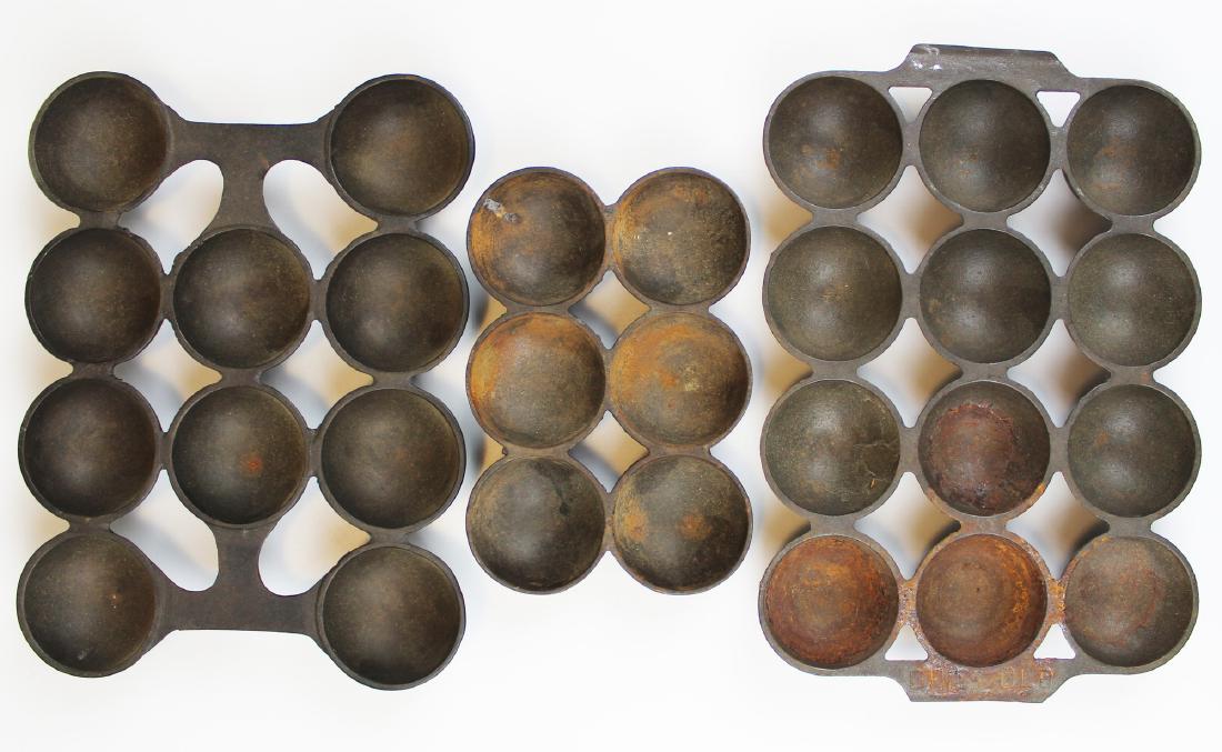 three cast iron popover pans including Griswold: three late 19th c popover pans including #947 Griswold Brownie cake pan No 9, early 10 ring #947 pan, & an unmarked 6 ring pan, lengths 10 1/2", 9 1/2", 6 1/2"