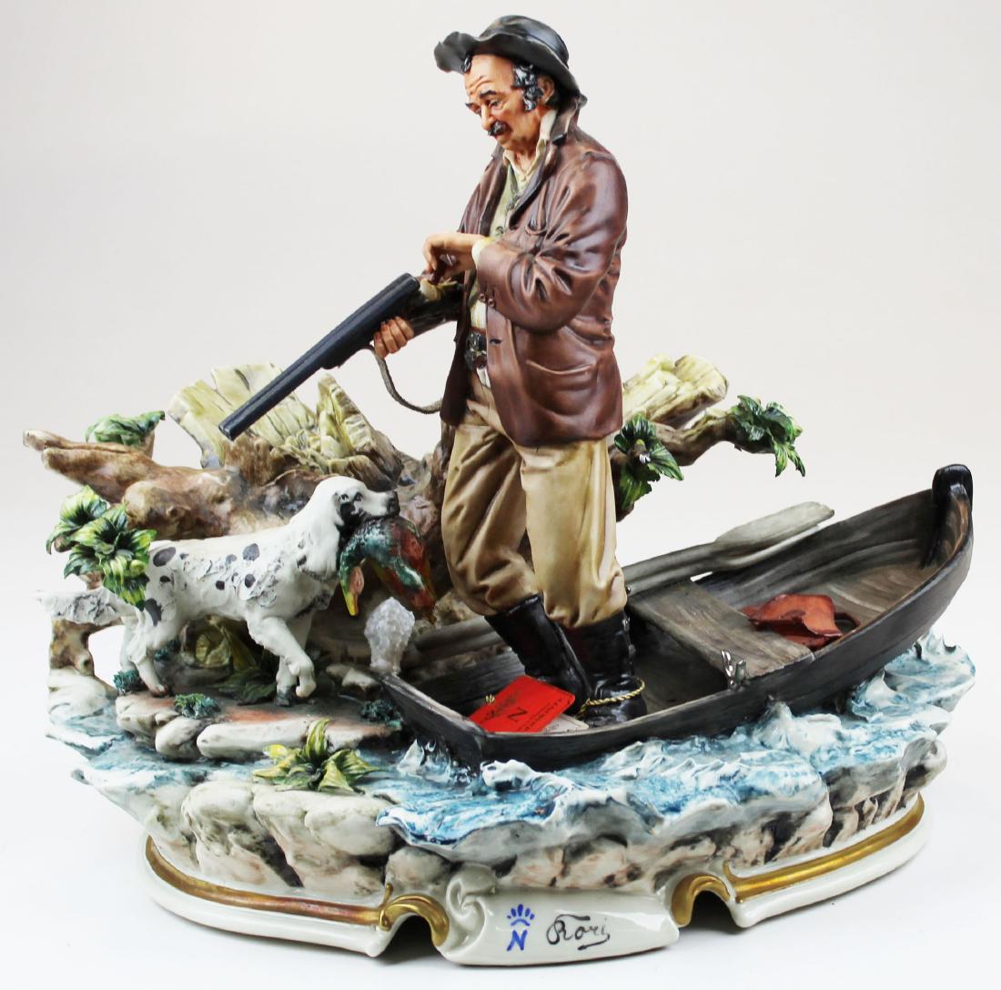 Capodimonte porcelain group of hunter with dog: contemporary Capodimonte La Medea fine porcelain figural group of hunter in boat reloading shot gun with dog retrieving duck artist signed "Rori", with original tag 12" x 13" x 9"