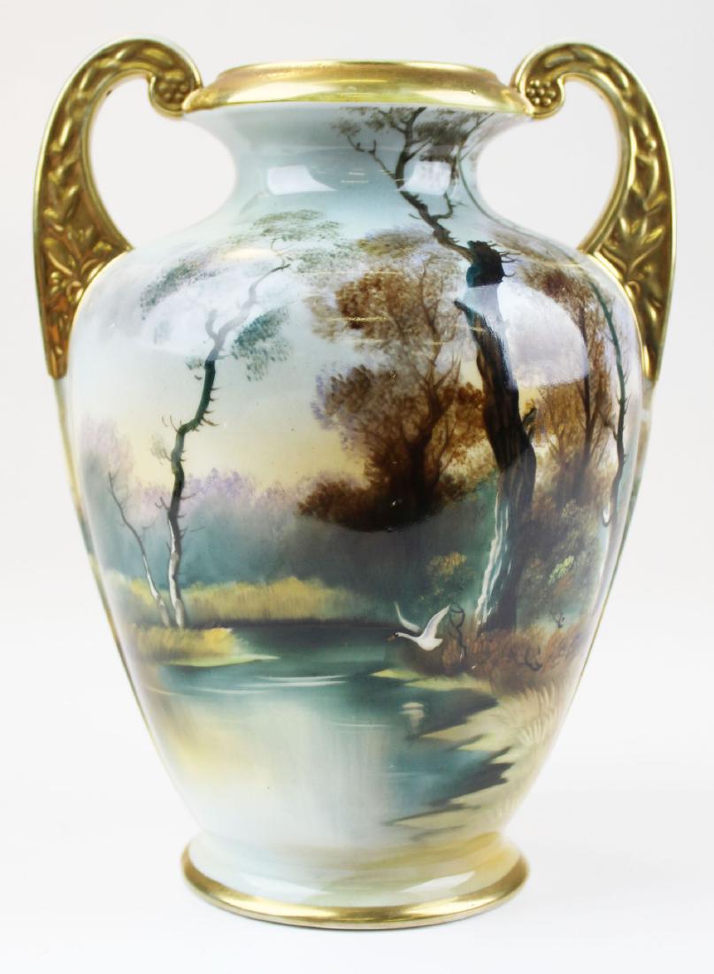 Nippon Morimura scenic hand painted vase: Nippon Morimura scenic hand painted amphora form vase depicting autumn landscape of swans flying over lake, with double handles and gilt accents 9.5" x 7"