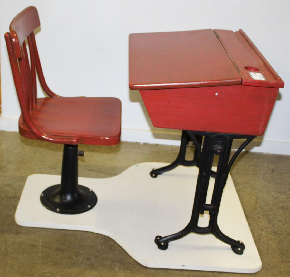 vintage 1940's iron school desk in red paint: vintage 1940's child's iron school desk in later red paint, affixed to painted board