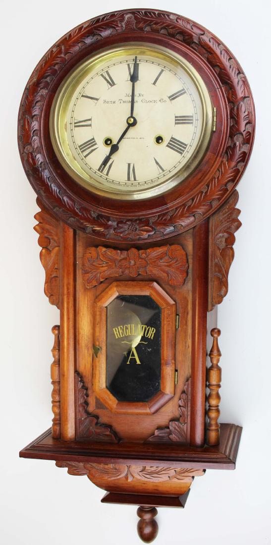 late 20th c. Seth Thomas regulator wall clock: late 20th c. Victorian style reproduction Seth Thomas regulator wall clock in carved mahogany and assorted hardwood case 32" x 13" x 5.5"