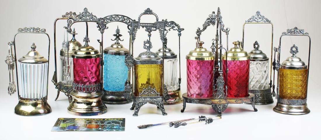 A collection of 9 pickle castors: A collection of 9 pickle castors including a double frame quilted cranberry, cranberry coin spot, ribbed opalescent, blue opalescent swirl, blue frosted daisy button, 3 clear pattern, square amber flo