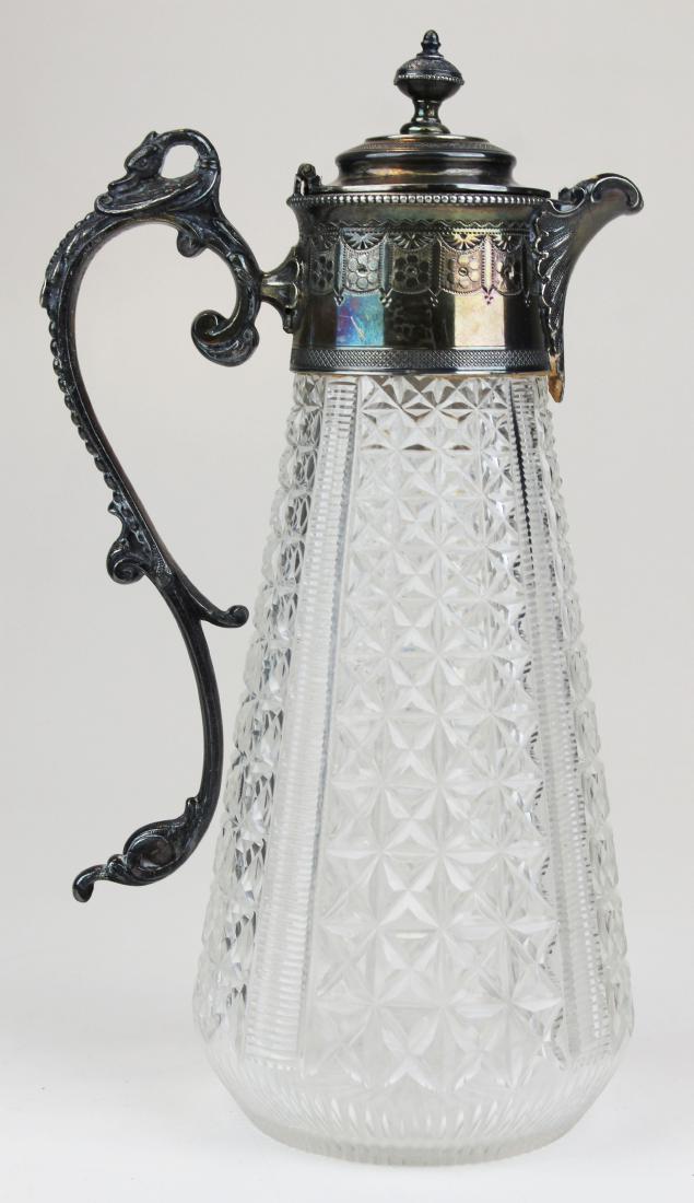 Fine Victorian silver plate & cut glass pitcher: Fine Victorian silver plate and cut pattern glass pitcher with a swan figural handle, quilted cut glass tapered body with 4 cut vertical ribs. Top numbered 0264. Hing is loose. 11" h.