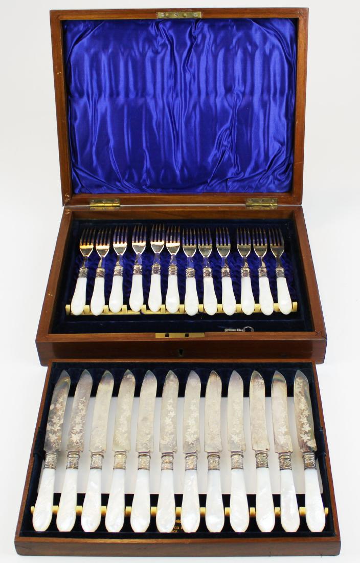 Cased mop lunch set: Victorian mother of pearl handle engraved cased lunch set. 12 forks and 12 knives. Purple satin liner. Engraved knives. Marked EP S H & H. Lift out tray to forks. Not monogramed. Has key. Very Fine co
