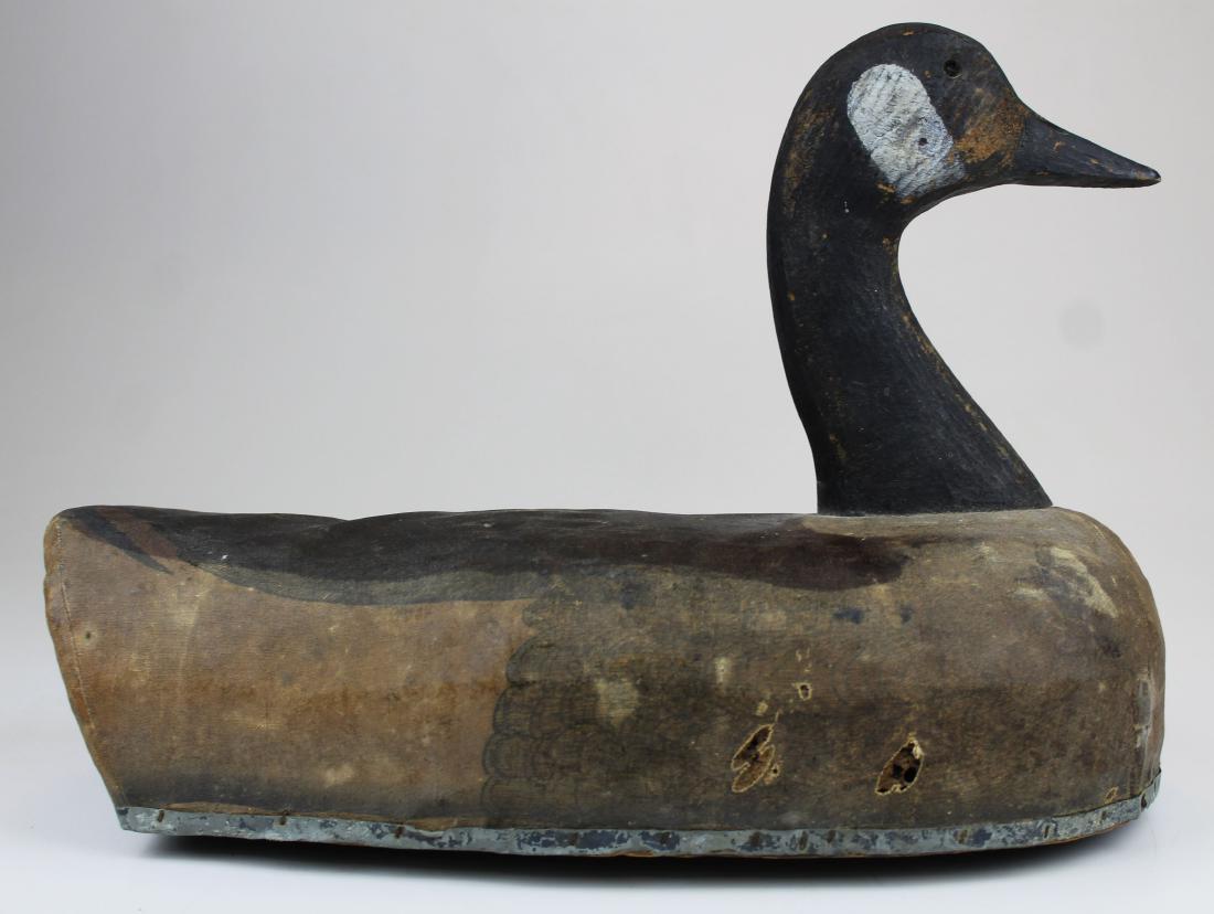 Early 20th c Canadian goose decoy: Early 20th c Canadian goose decoy. Canvas covered body, machined head, glass eye (missing one), wood bottom with tin tack edge, good original paint, working bird. Possibly a Lesser Canadian Goose. 15"