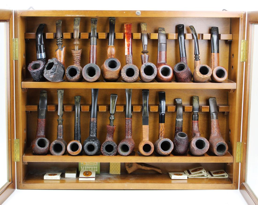 Lot of Estate pipes in hanging pipe rack: Contemporary hanging pipe case with twenty two burl pipes including Petersons, Bari Matador, Stone Age, Ehrlich, Don Giant etc, All with signs of use and teeth marks on Stems as found