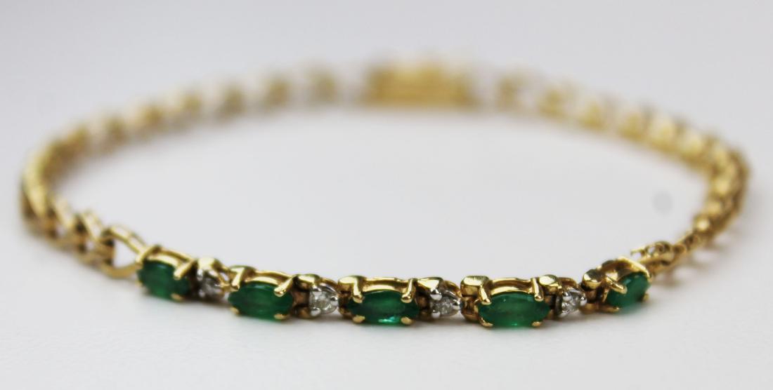 Diamond, emerald, & 14k yellow gold bracelet: A 14k yellow gold bracelet set with 5 marquis cut emeralds 5 mm x 2 1/2 mm each and 4 2pt diamonds. 7" long. 5.1 grams t.w.
