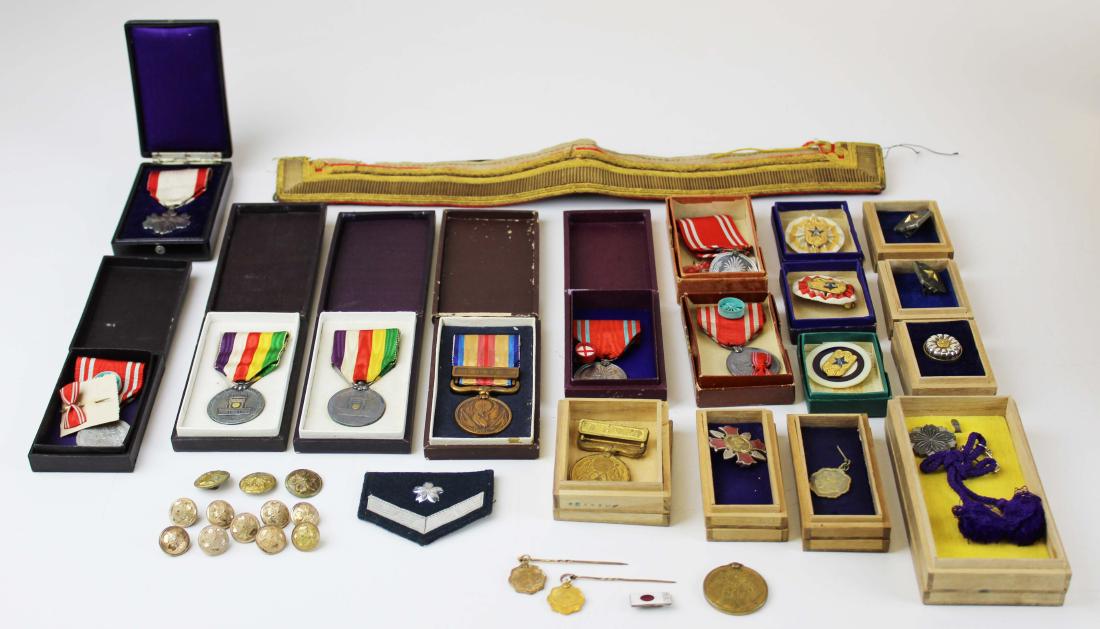 Collection Of Japanese medals and badges: Lot of Japanese WWII Era Badges most in their original boxes- Silver Wound badge; China Incident Medal, KIA badge, 2 Showa Enthronement Bages, Four Japanese Red Cross badges with rosettes; Two Russo/J