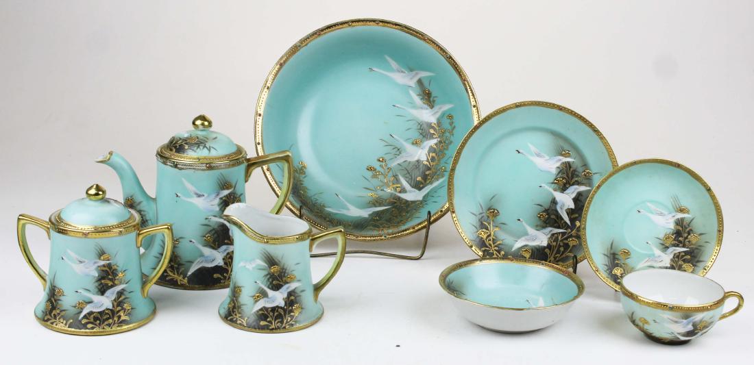 Nippon porcelain tea set with gilt raised enamel: 1920's Nippon porcelain tea and luncheon set with gilt raised enamel jeweled border and handpainted geese decoration, consisting of teapot, sugar, creamer, 6 teacups and saucers, 6 side bowls, 6 desse