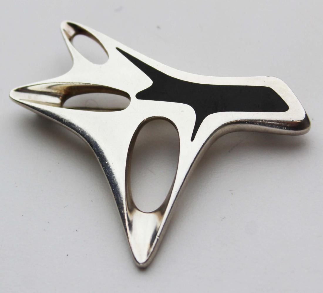 Sterling Georg Jensen Henning Koppel brooch: Sterling Silver and Enamel Brooch pin, Henning Koppel, Georg Jensen, of abstract form with black enamel inlay, lg. 2 1/2 in., no. 323, signed Georg Jensen, maker's mark HK, Denmark.