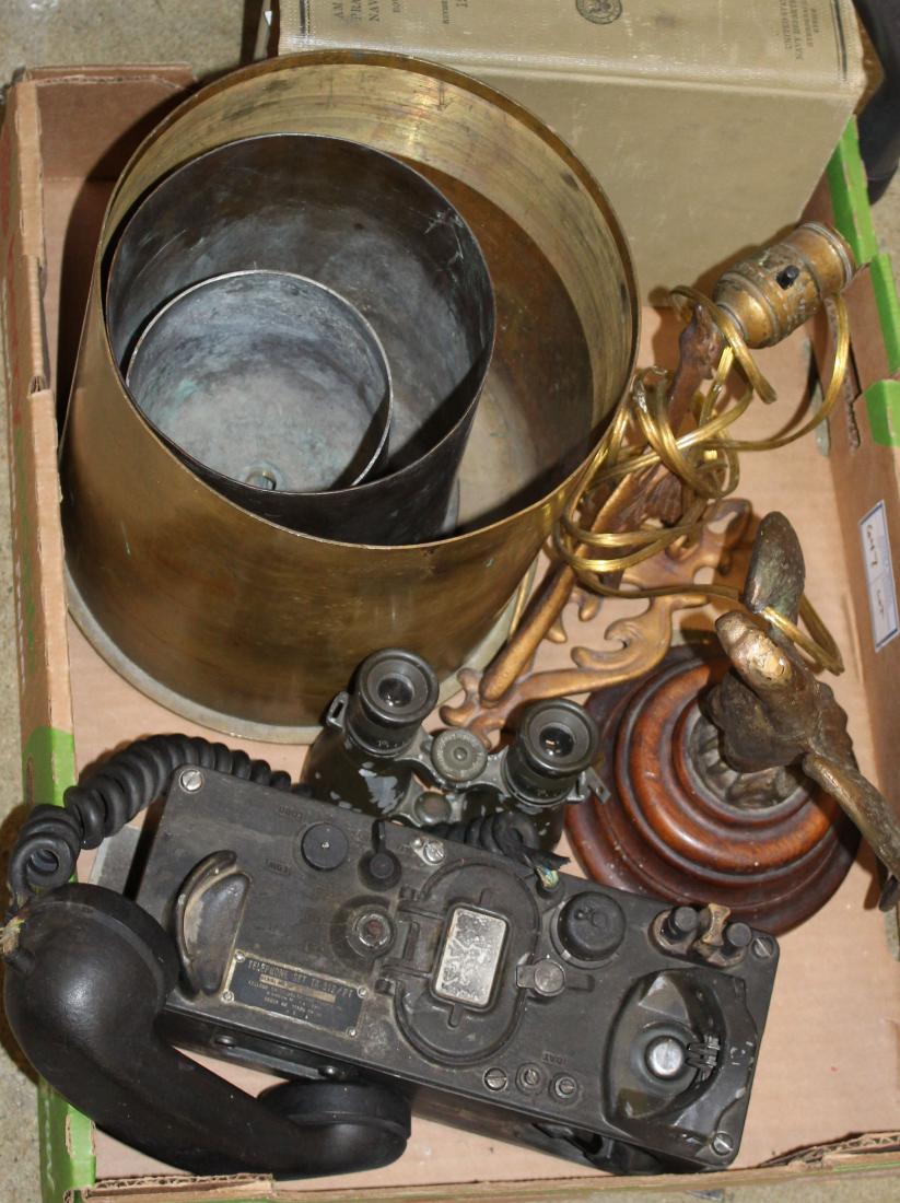 US military: US military grouping including 3 trench art shells, Vietnam era field phone model TA 312, cast iron gilt eagle, 1938 Naval Navigation book, and binoculars.